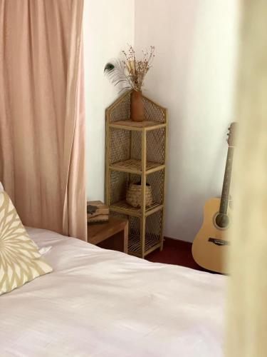 a bedroom with a bed and a guitar in a room at Le Cabanon in Hiriketiya