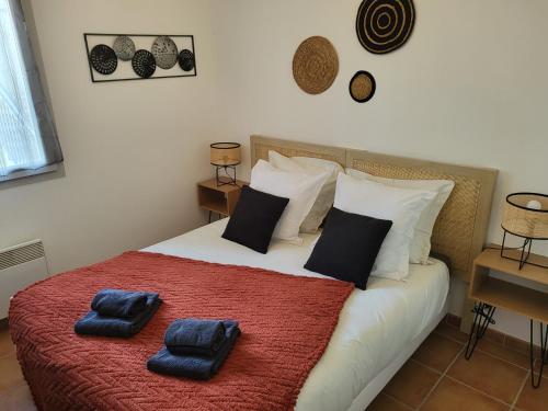 a bedroom with a bed with two blue pillows on it at Le Pietra in Uzès