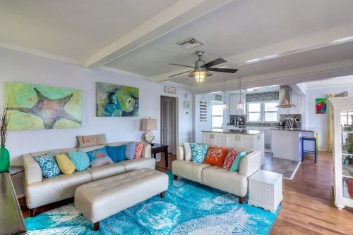 a living room with two couches and a kitchen at Three Oars Beach Bungalow in Daytona Beach