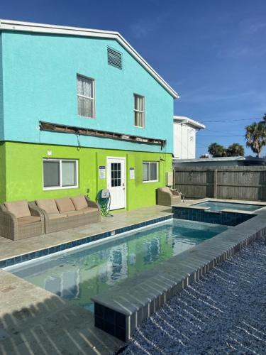 a house with a swimming pool in front of a house at Three Oars Beach Bungalow in Daytona Beach