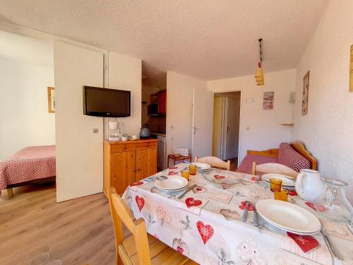 une cuisine avec une table recouverte d'une nappe dans l'établissement Spacieux appart 2 pièces - skis aux pieds - balcon sud - proche commerces - parking dispo - FR-1-344-1048, aux Menuires