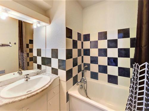 une salle de bain avec un lavabo et une baignoire dans l'établissement Appartement chaleureux, pied des pistes, balcon, 4 pers. - FR-1-267-208, au Corbier