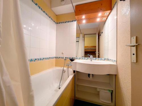 une salle de bain avec un lavabo et une baignoire dans l'établissement Studio classique à Reberty 1850 - Accès direct aux pistes, 4 pers. - FR-1-344-1006, aux Menuires