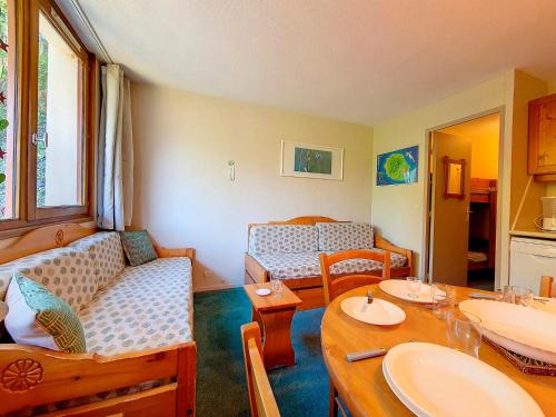 un salon avec un canapé et une table dans l'établissement Studio classique à Reberty 1850 - Accès direct aux pistes, 4 pers. - FR-1-344-1006, aux Menuires