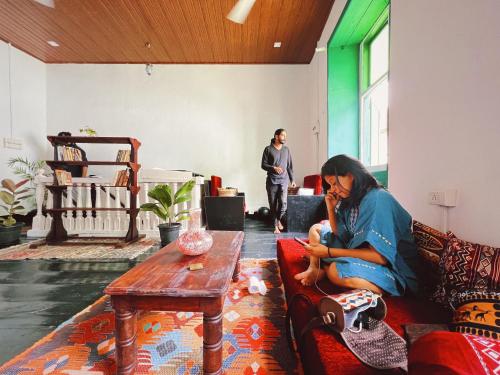 a woman sitting on a couch in a living room at Bunk house Fort Kochi in Cochin