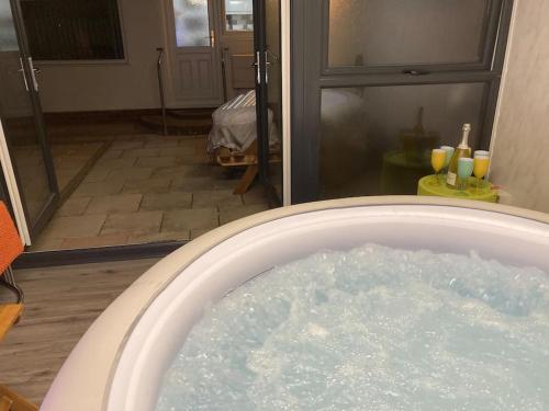 uma banheira cheia de água num quarto em 17 Cheerful 2 bed bungalow, hot tub/gym/pool table em Prestatyn
