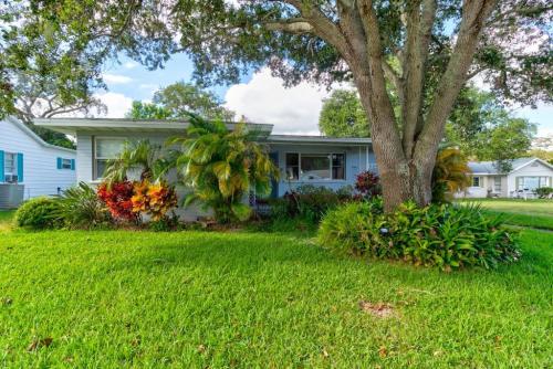 a house with a tree in a yard at The Good Ole Days King Bed Pet Friendly in Daytona Beach