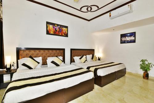 two beds in a hotel room with two bedsvisor at Hotel Sai Sham in Amritsar