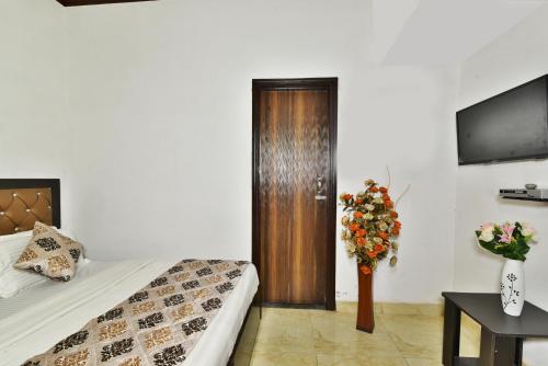 a bedroom with a bed and a wooden door at Hotel Sai Sham in Amritsar