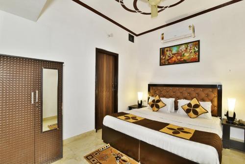 um quarto com uma cama grande e um espelho em Hotel Sai Sham em Amritsar