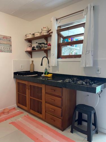 cocina con encimera, fregadero y ventana en Casa Aconchego - Arraial D Ajuda- Bahia, en Arraial d'Ajuda