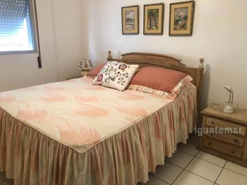 1 dormitorio con 1 cama grande con sábanas y almohadas rosas en Melhor de Guarujá - Praia de Pitangueiras, en Guarujá