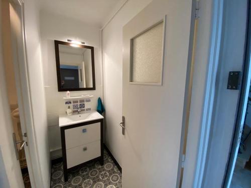 a white bathroom with a sink and a mirror at Ty Gavrinis - T2- Centre Bourg - 100m de la mer in Larmor-Baden