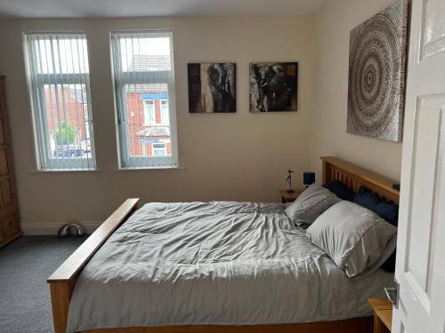 a bed in a bedroom with two windows at Urban view in Doncaster