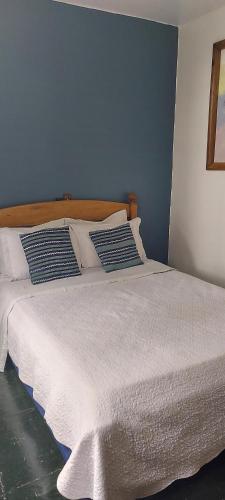 a bed with white sheets and pillows on it at Pousada Charitas Saint Malo in Niterói