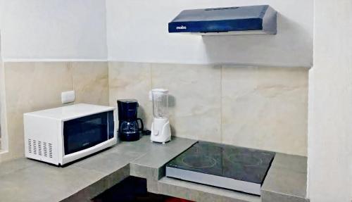 cocina con microondas y licuadora en un mostrador en El Departament del Port, en Cancún