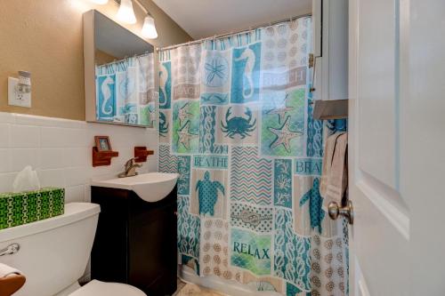 オーモンド・ビーチにあるTropical Retreatのバスルーム(シャワーカーテン、トイレ、シンク付)