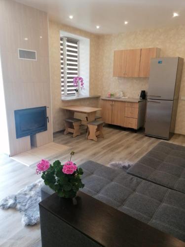 uma cozinha com um sofá e um frigorífico num quarto em Apartamenti pie Lienes em Gardene
