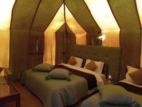 a bedroom with two beds in a tent at Fabulous Desert Camp in Merzouga