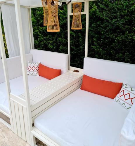 two white porch swings with red pillows on a porch at Villaozil in Sapanca