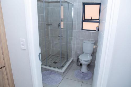 a bathroom with a shower and a toilet at The Blyde Modern Oasis Pretoria in Pretoria