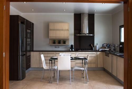 uma cozinha com uma mesa e cadeiras em English house em Ponta Delgada