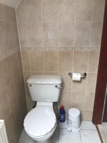 a bathroom with a toilet and a roll of toilet paper at Executive Serviced Apartments 3 in Forfar