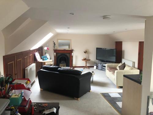 a living room with a couch and a fireplace at Executive Serviced Apartments 3 in Forfar