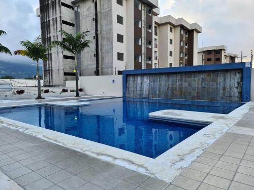 a swimming pool with blue water in a building at Apartment with city view in Oasis de San José in San José