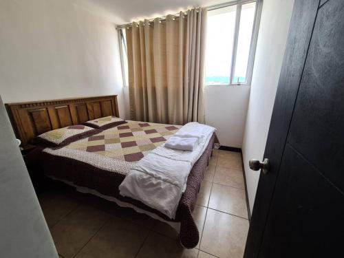 a small bedroom with a bed and a window at Apartment with city view in Oasis de San José in San José