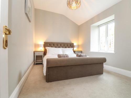 a bedroom with a large bed and a window at Wild Acres in Helston