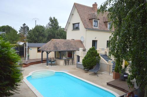 uma casa com piscina em frente a uma casa em La Pause Cauchoise em Vittefleur