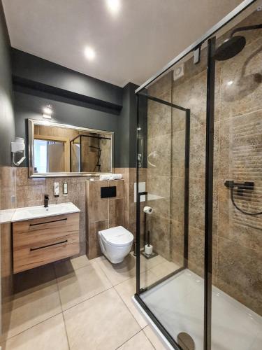 a bathroom with a toilet and a glass shower at Kamienica Morska Gdynia in Gdynia