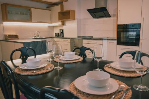a table with four chairs and wine glasses on it at 164 apt. in Val di Vizze