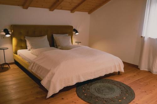 a bedroom with a large bed with white sheets and a rug at 164 apt. in Val di Vizze