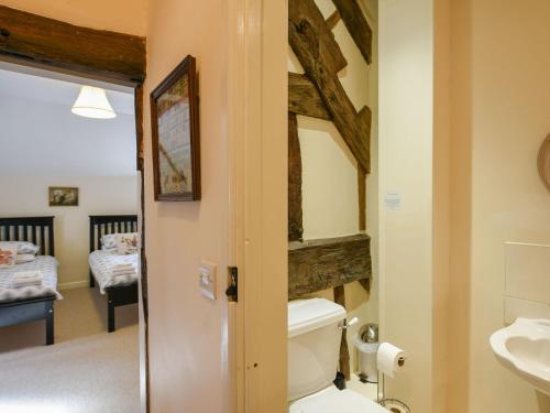 a bathroom with a toilet and a sink and a bedroom at Garth Ucha in Llanyblodwel