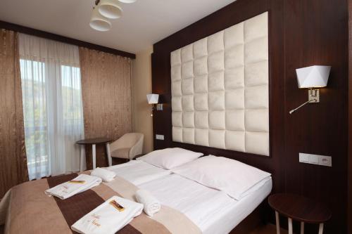 a bedroom with a large white bed and two tables at Willa Nova in Wisła