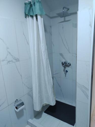 a shower with a white shower curtain in a bathroom at La Cascada 2 in Posadas