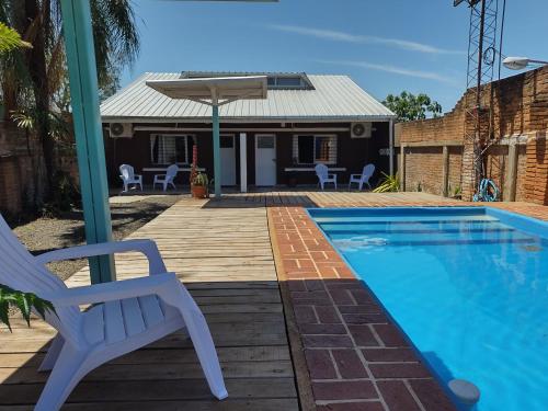 uma piscina com uma cadeira e uma casa em La Cascada 2 em Posadas