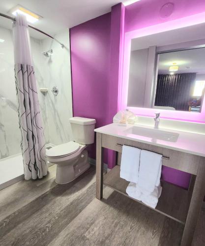 a purple bathroom with a toilet and a sink at Motel 6 Tuscaloosa AL University in Tuscaloosa