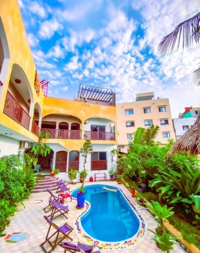 un complexe avec une piscine devant un immeuble dans l'établissement La Maison Abaka, à Dakar