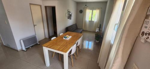 a kitchen with a wooden table and a living room at Andino Apartaments Rental Rivadavia in San Juan