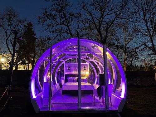 un túnel púrpura con camas por la noche en Tubbo Experience by Camping Osuna, en Madrid