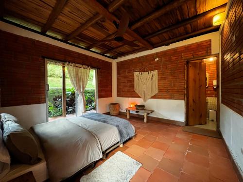a bedroom with a bed and a large window at Origen Hostel in El Zaino