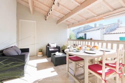 patio con mesa y sillas en el balcón en La Virginie - Suite Ile'Ô en La Couarde-sur-Mer