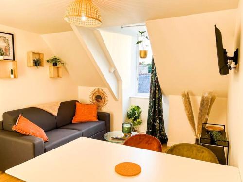un salon avec un canapé et une table dans l'établissement La Nature au Coeur de Guingamp - ParkinG -, à Guingamp