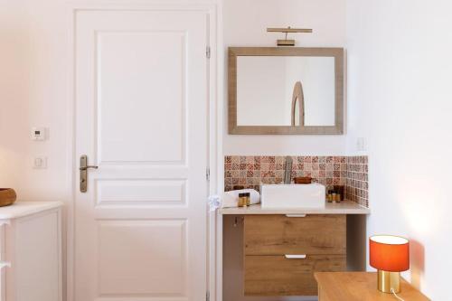 a bathroom with a white door and a sink at Les Oules Vertes YourHostHelper classé 3 étoiles in Théoule-sur-Mer