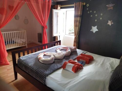 een slaapkamer met een bed met 3 paar slippers bij Charmante maison in Saint-Michel-le-Cloucq