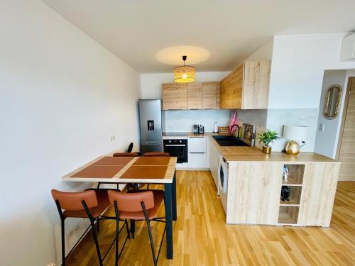 une cuisine avec une table et des chaises dans une pièce dans l'établissement Ajaccio T2 grand standing neuf vue mer centre-ville & plages, à Ajaccio