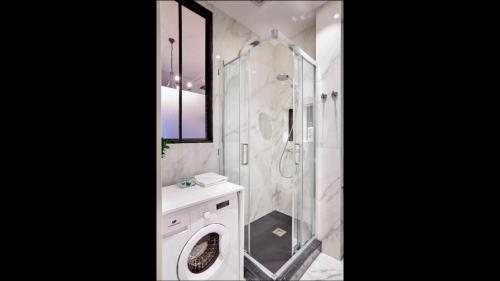 een badkamer met een douche en een wasmachine bij Le Gatsby 3 étoiles in Aix-les-Bains